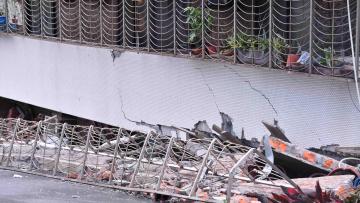 塌陷的民宅，一樓已消失，只看到鐵窗扭曲變形。畫面來源/ 台北市政府
